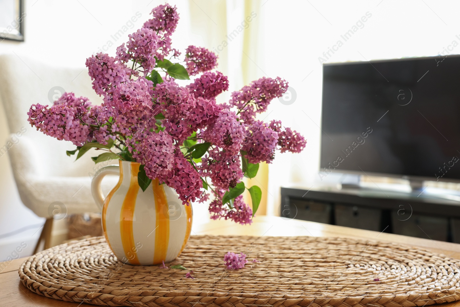 Photo of Beautiful lilac flowers in vase on table at home. Space for text