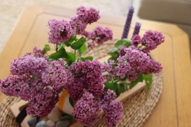 Photo of Beautiful lilac flowers in vase on table indoors, above view