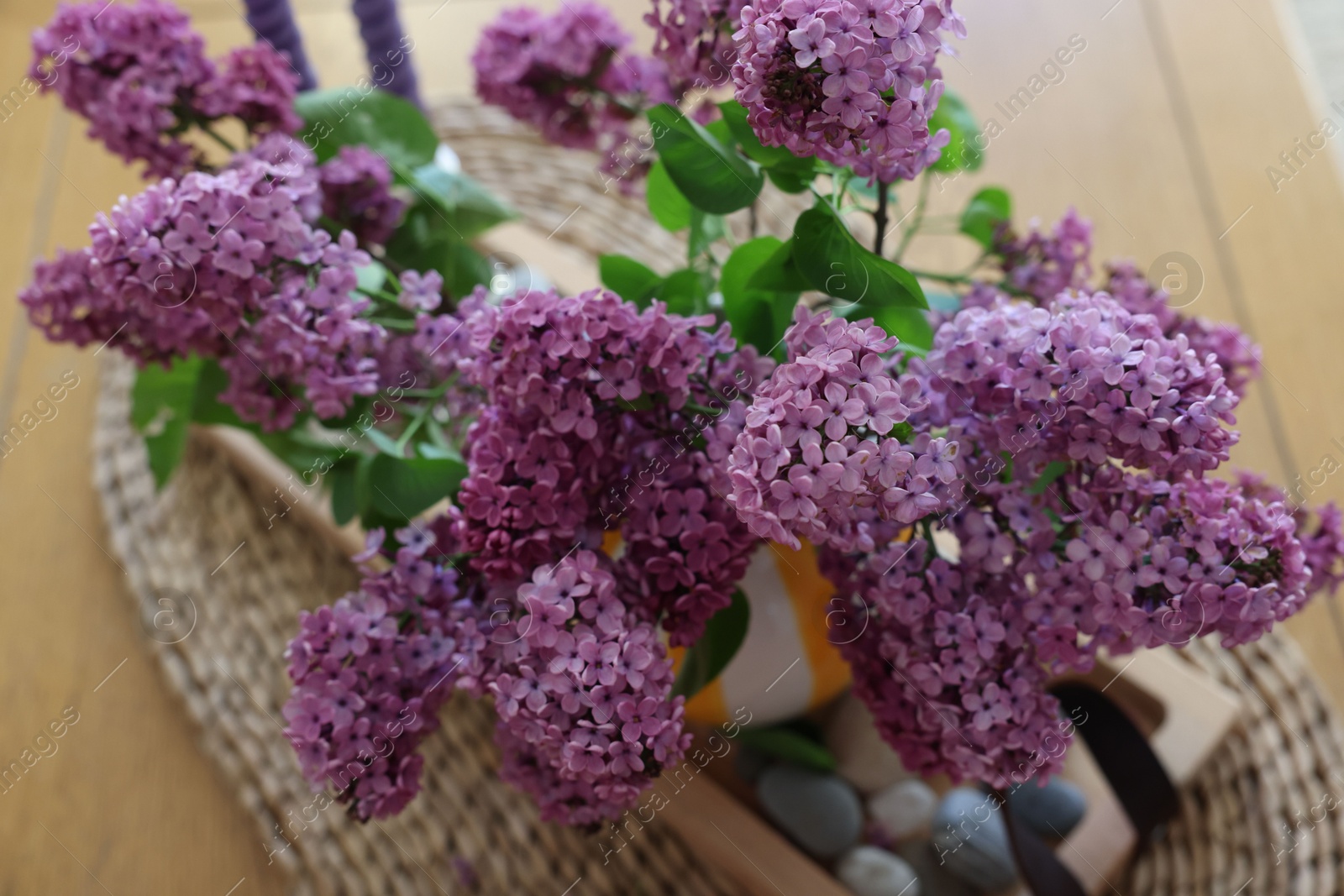 Photo of Beautiful lilac flowers in vase on table indoors, above view