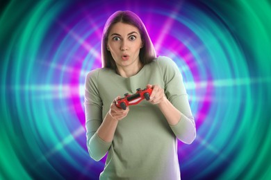 Image of Excited woman playing video game with controller on color background. Light behind her