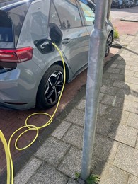 Photo of Modern electric car charging from station outdoors