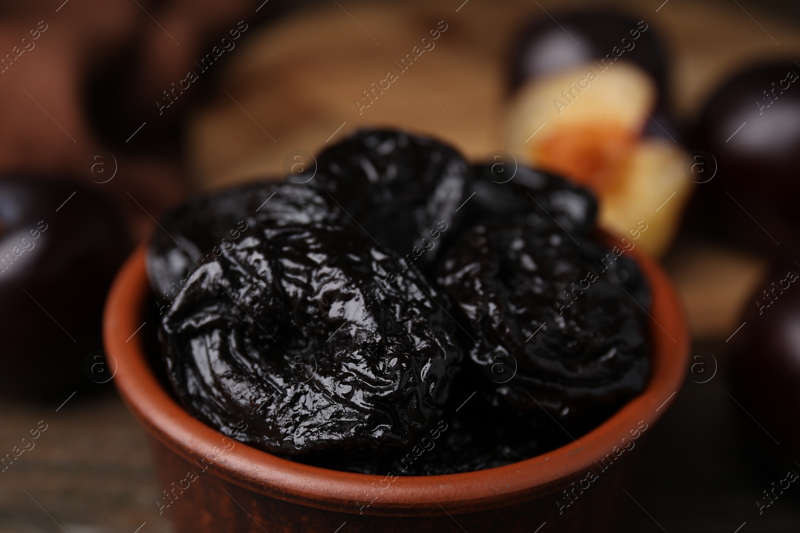 Photo of Tasty dried plums (prunes) in bowl on table, closeup