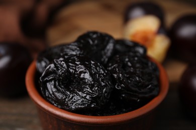 Photo of Tasty dried plums (prunes) in bowl on table, closeup