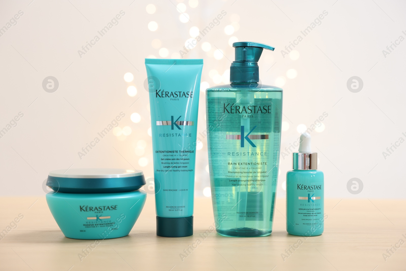 Photo of Leiden, Netherlands - June 11, 2024: Kerastase hair care cosmetic products on wooden table against light background with blurred lights