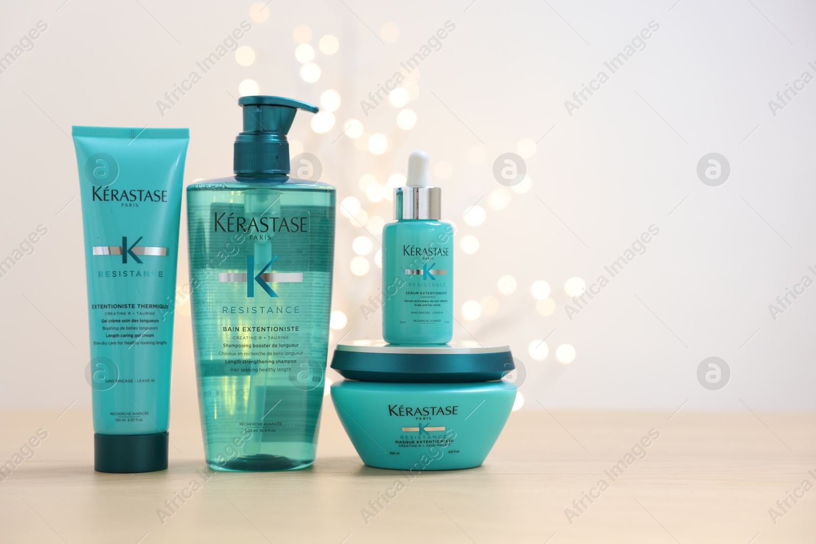 Photo of Leiden, Netherlands - June 11, 2024: Kerastase hair care cosmetic products on wooden table against light background with blurred lights, space for text