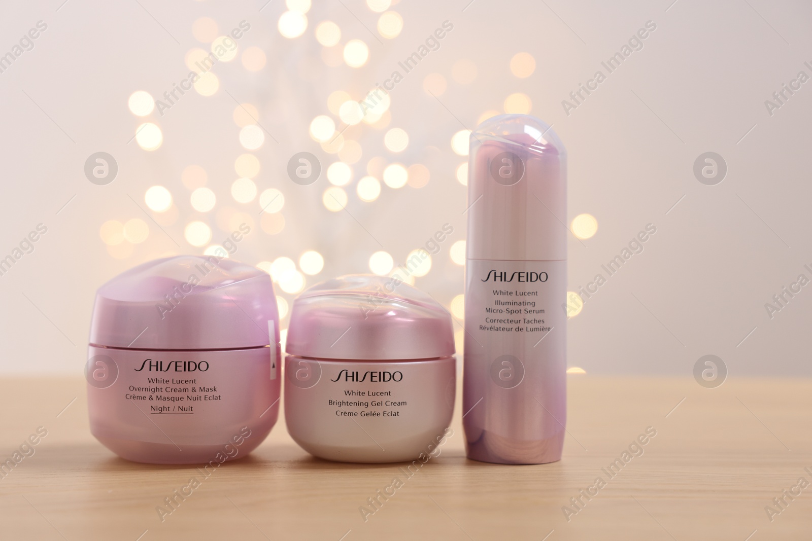 Photo of Leiden, Netherlands - June 11, 2024: Shiseido care cosmetic products on wooden table against light background with blurred lights, space for text