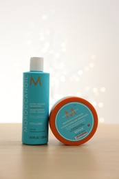 Photo of Leiden, Netherlands - June 11, 2024: Moroccanoil hair care cosmetic products on wooden table against light background with blurred lights