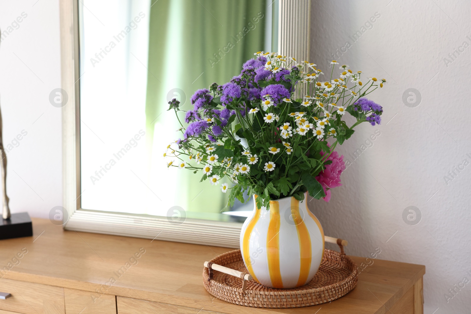 Photo of Vase with beautiful flowers on wooden table indoors, space for text