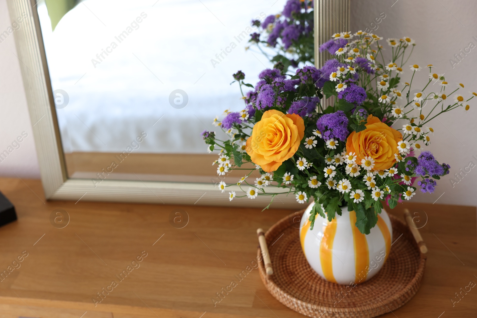 Photo of Vase with beautiful flowers on wooden table indoors, space for text