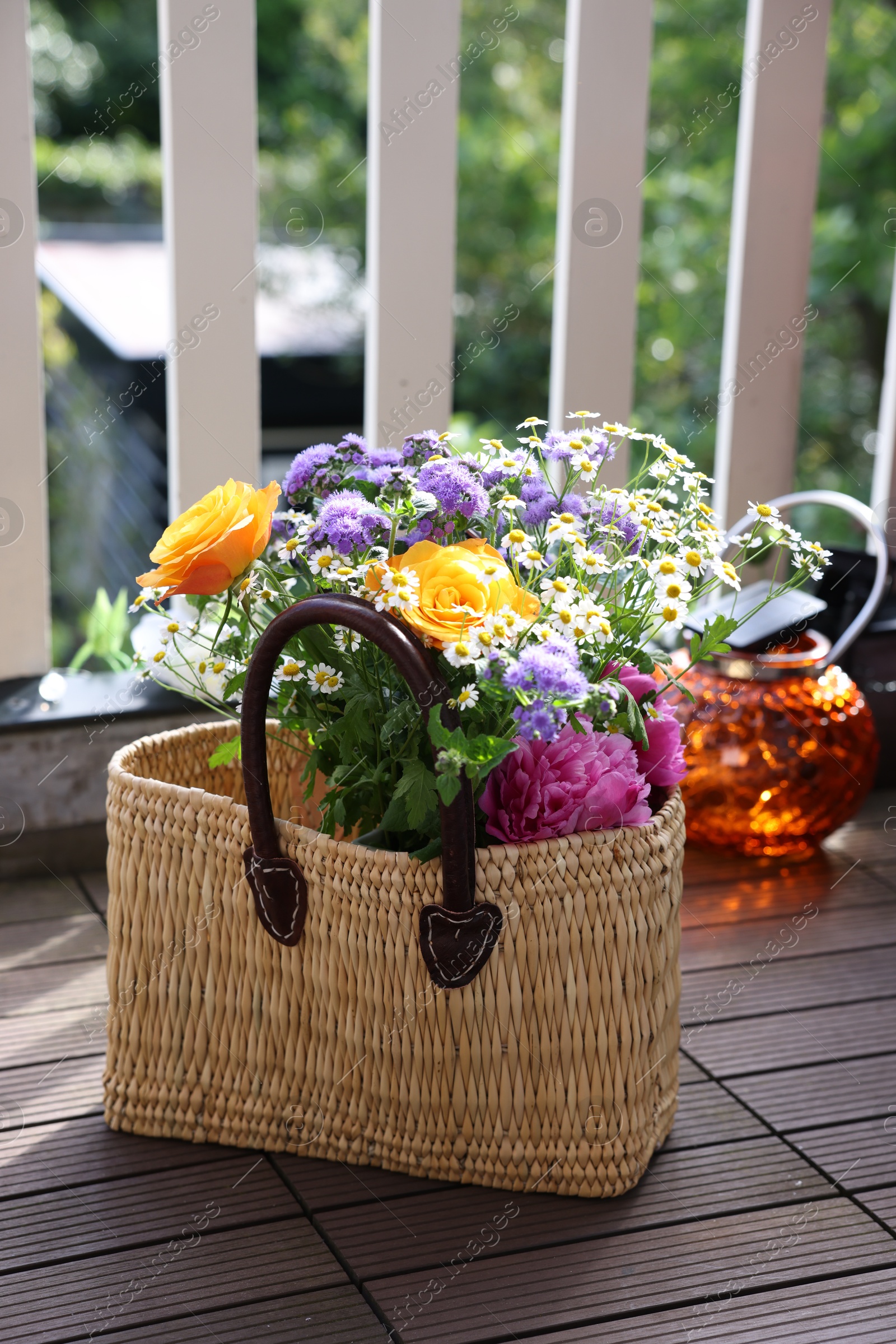 Photo of Wicker basket with beautiful aromatic flowers at balcony