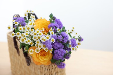 Wicker basket with beautiful flowers on table, closeup. Space for text