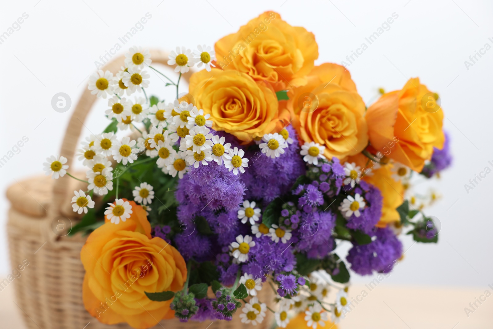 Photo of Wicker basket with beautiful flowers on white background, closeup