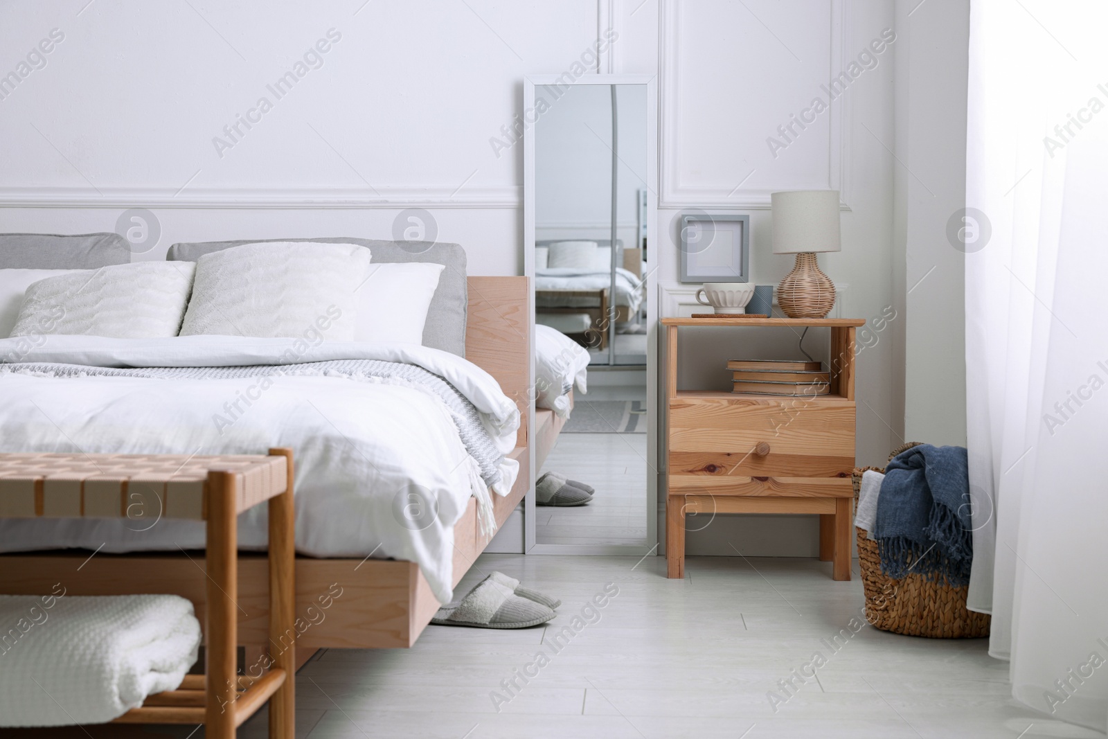 Photo of Stylish living room interior with bed, bedside table and lamp