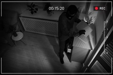 Image of Thief robbing house, view through surveillance camera