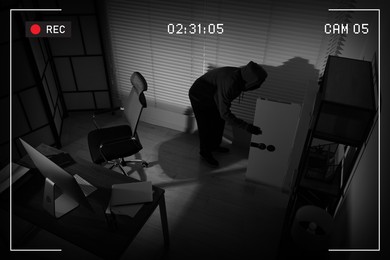 Thief robbing house, view through surveillance camera