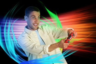 Man playing video game with controller on black background, motion blur effect. Colorful lights around him