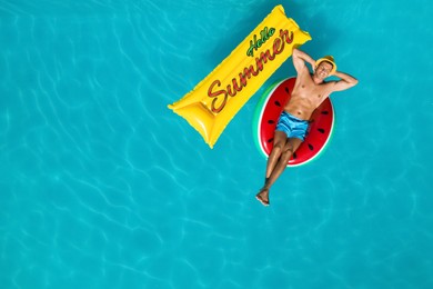 Hello Summer. Happy man with inflatable mattress and ring in swimming pool, top view