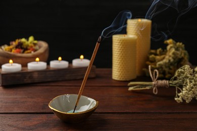 Aromatic incense stick smoldering on wooden table