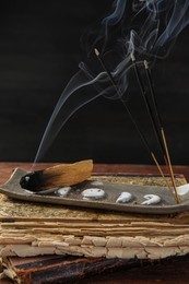 Aromatic incense sticks smoldering on wooden table