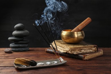 Aromatic incense sticks smoldering on wooden table