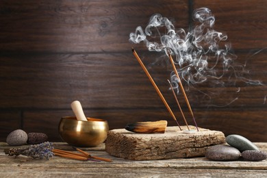 Photo of Aromatic incense sticks smoldering on wooden table