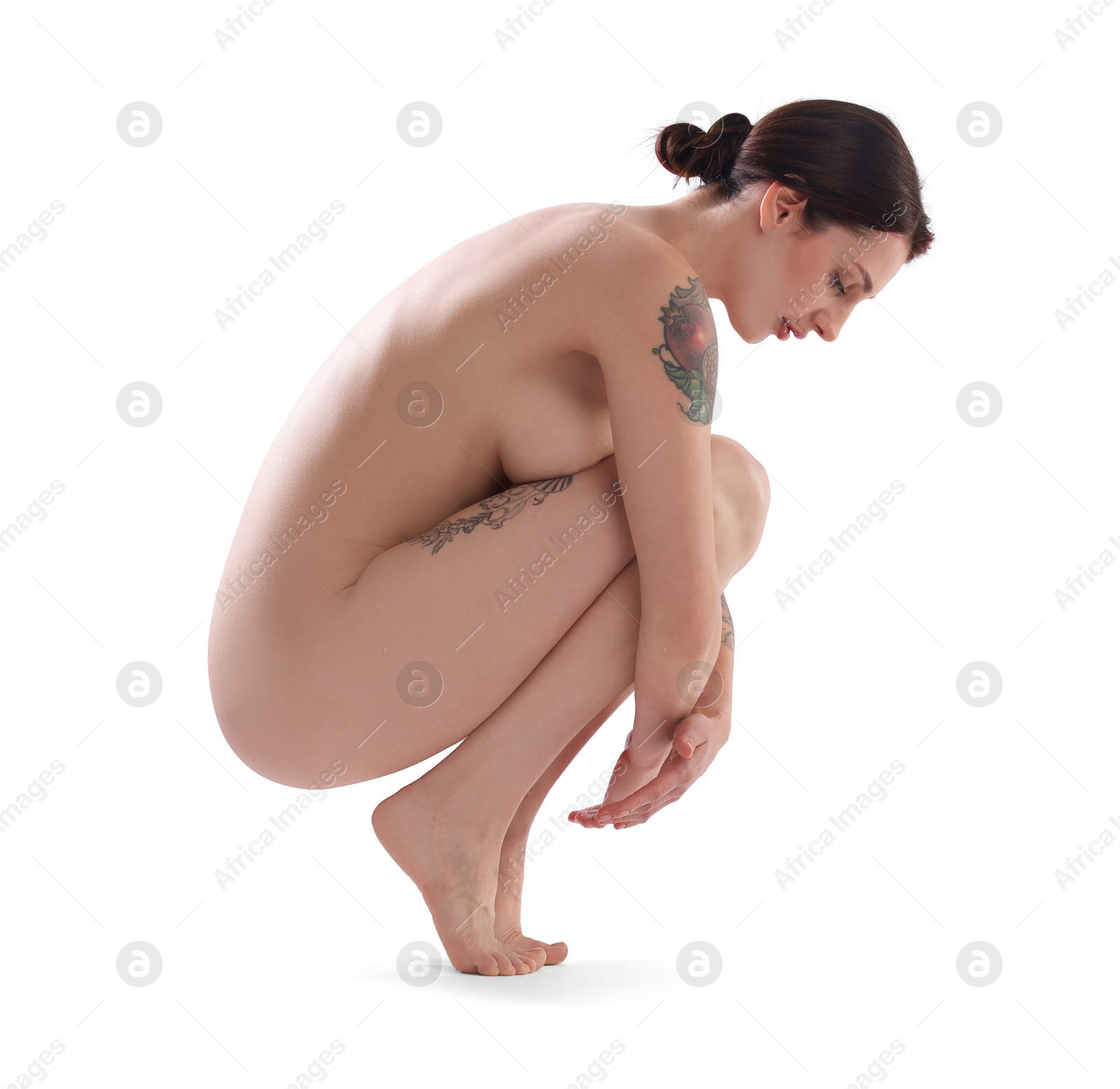 Photo of Beautiful nude woman with tattoos posing on white background