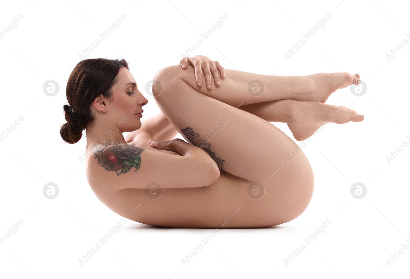 Photo of Beautiful nude woman with tattoos posing on white background