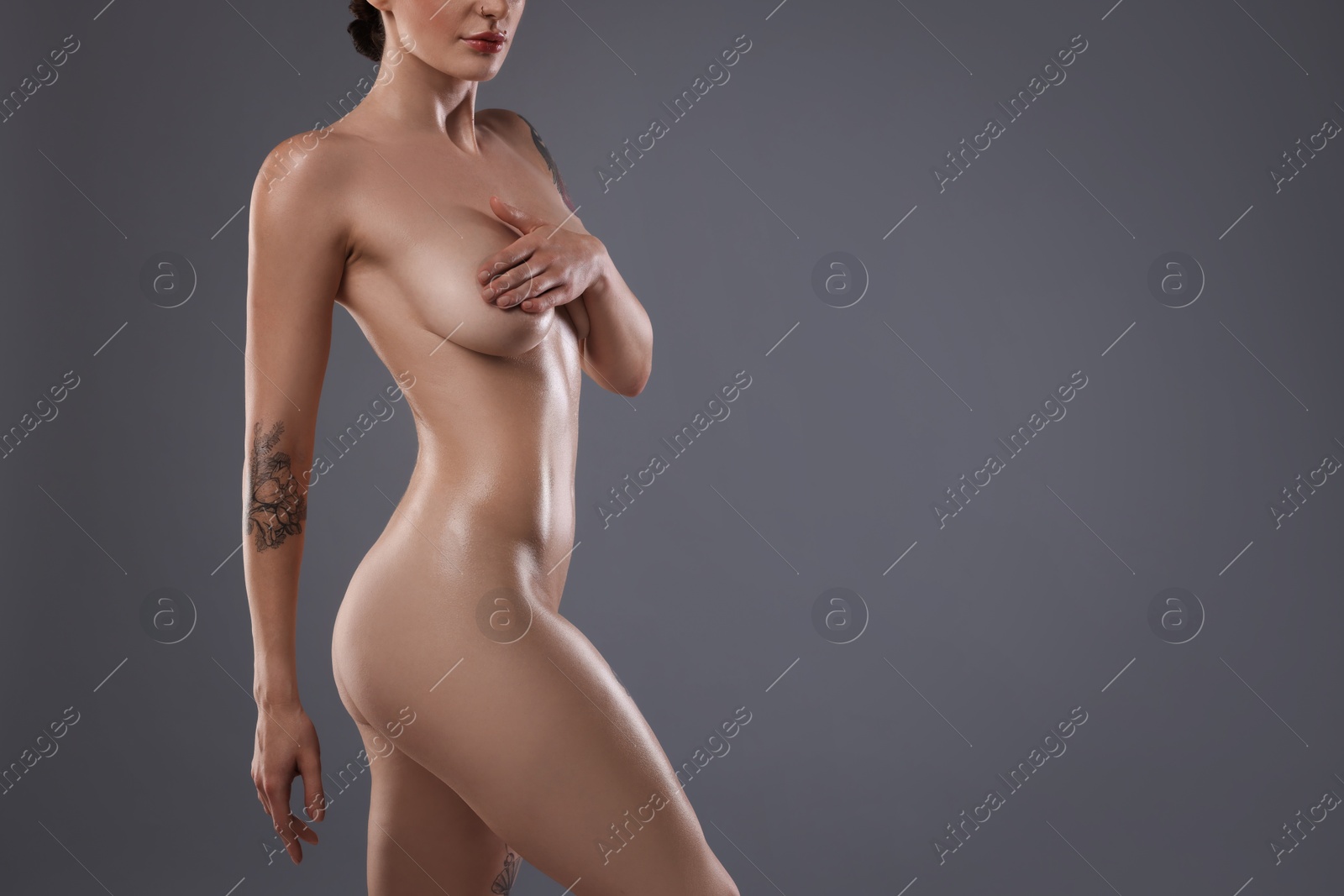 Photo of Nude woman on grey background, closeup. Space for text