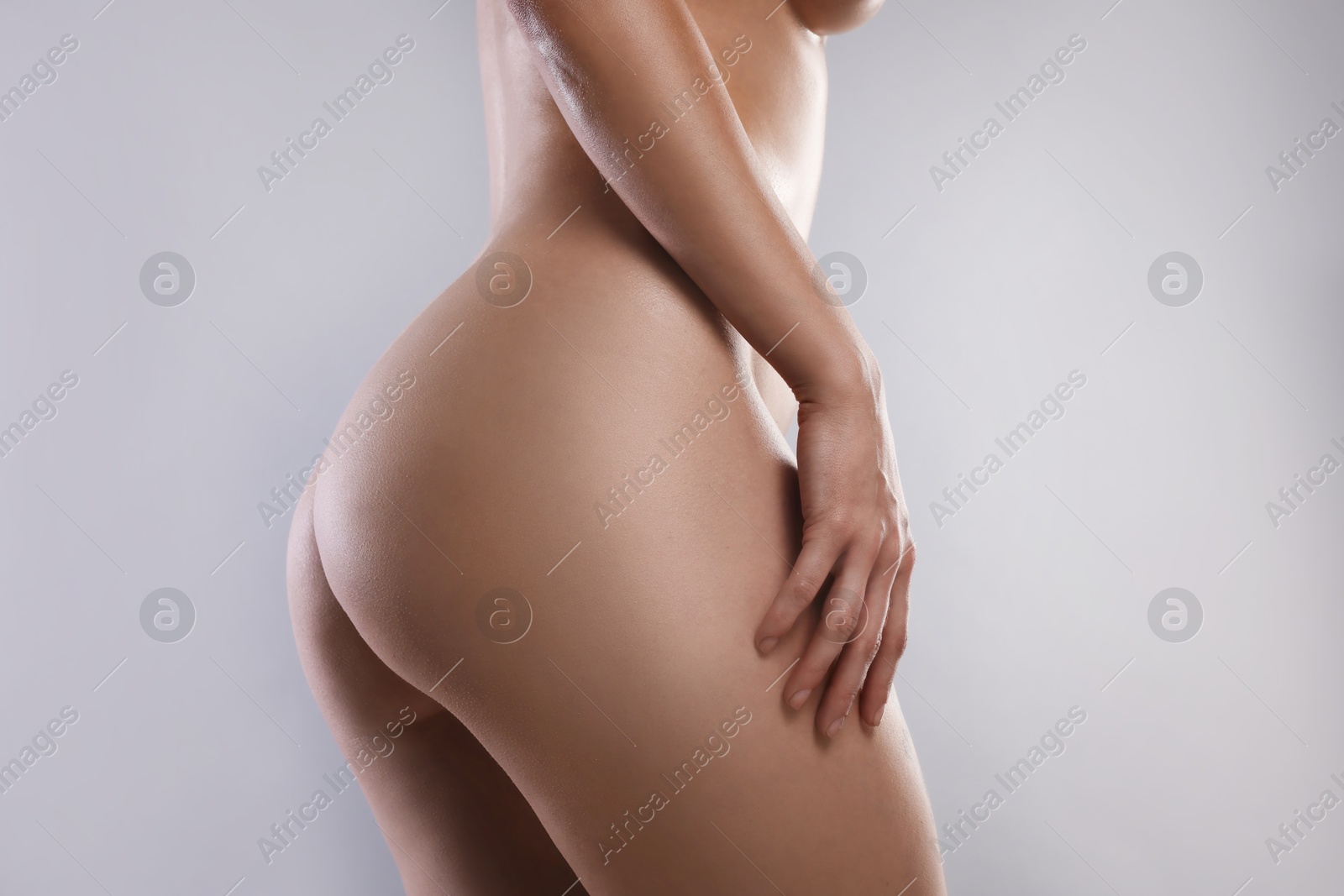 Photo of Nude woman on light grey background, closeup