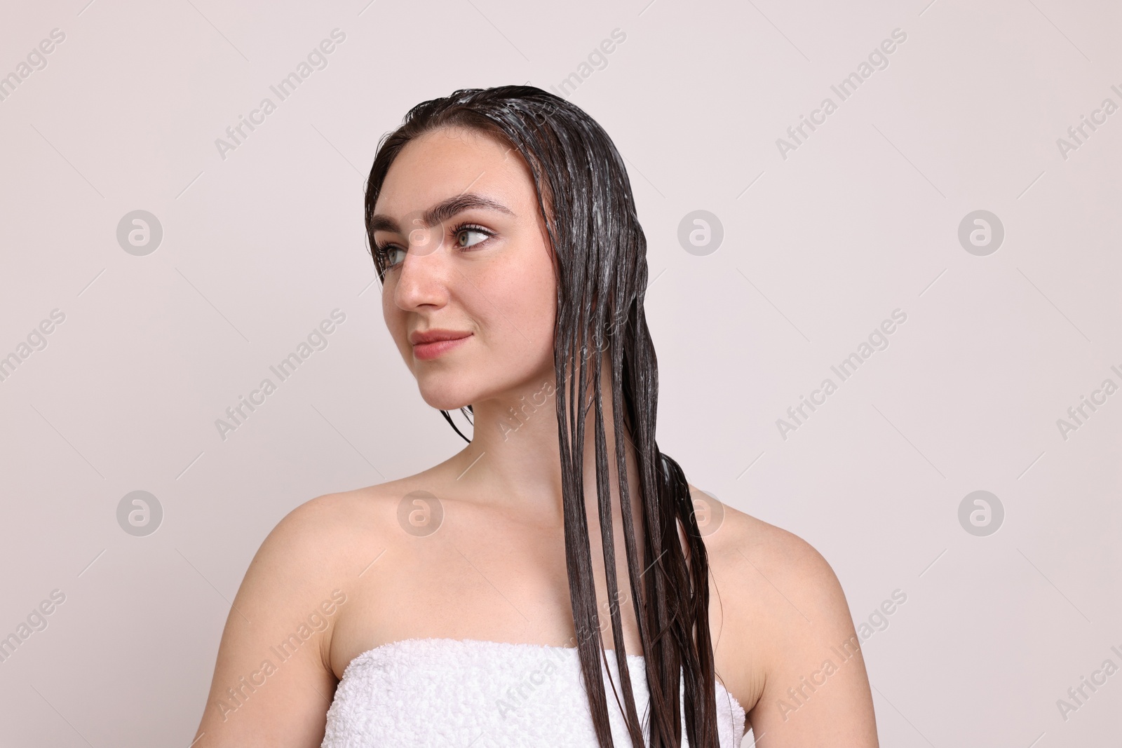 Photo of Beautiful woman with applied hair mask on light background