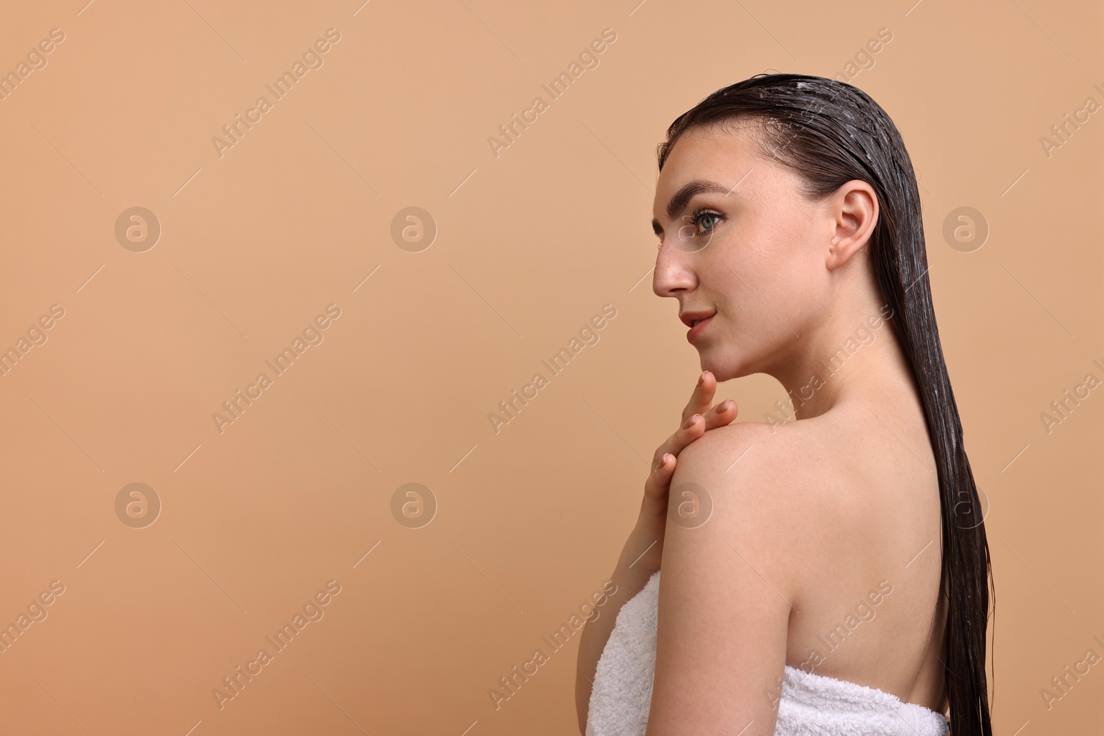 Photo of Beautiful woman with applied hair mask on beige background. Space for text
