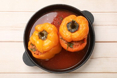 Photo of Tasty stuffed peppers in pan on light wooden table, top view