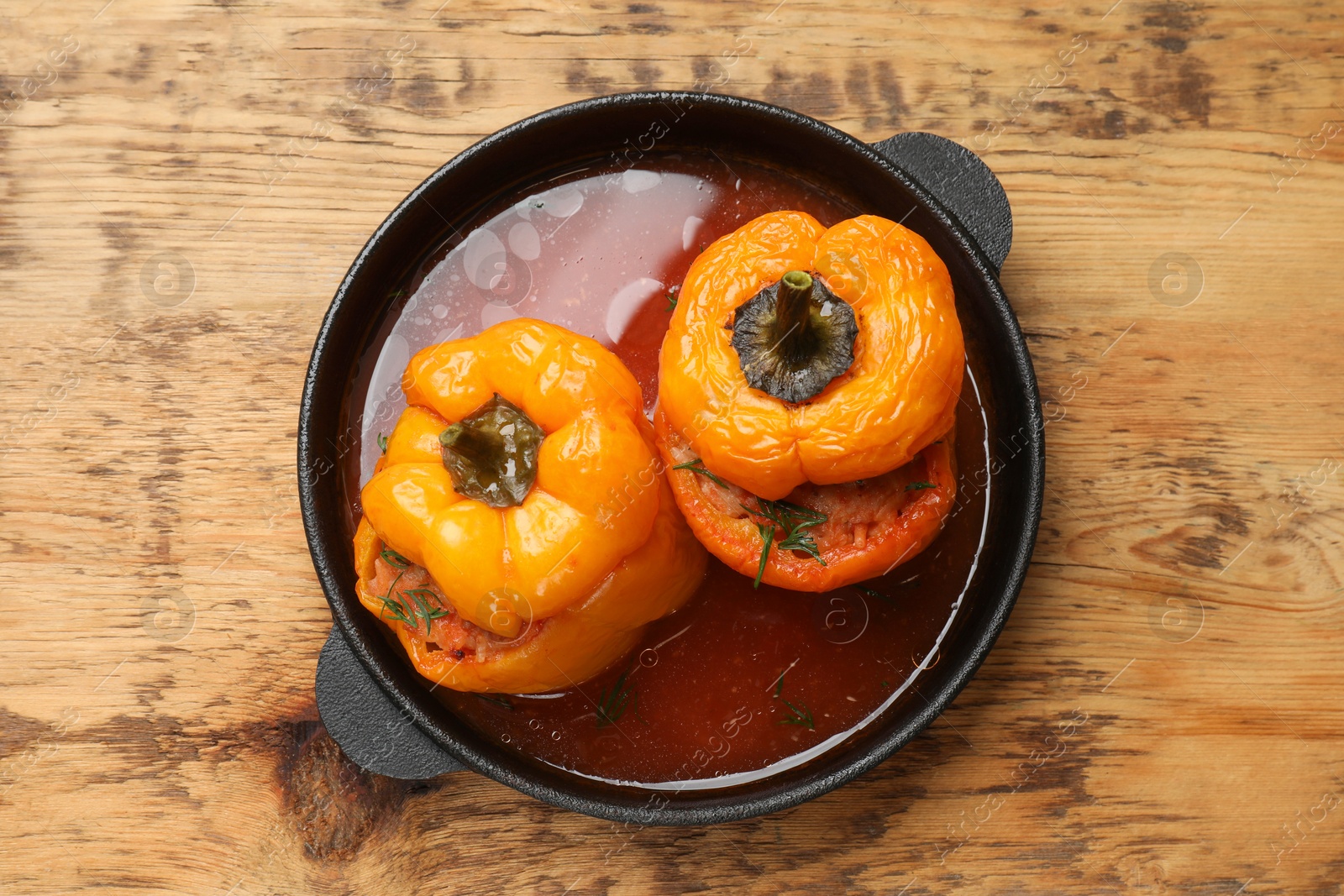 Photo of Tasty stuffed peppers in pan on wooden table, top view