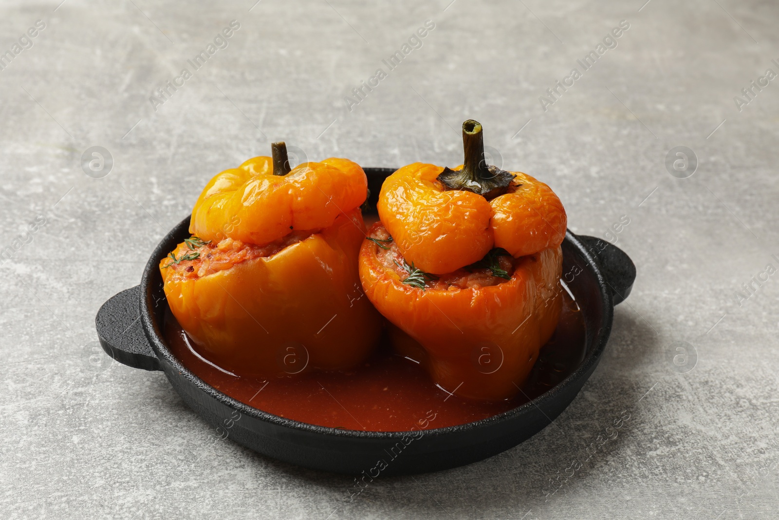 Photo of Tasty stuffed peppers on light grey table, closeup