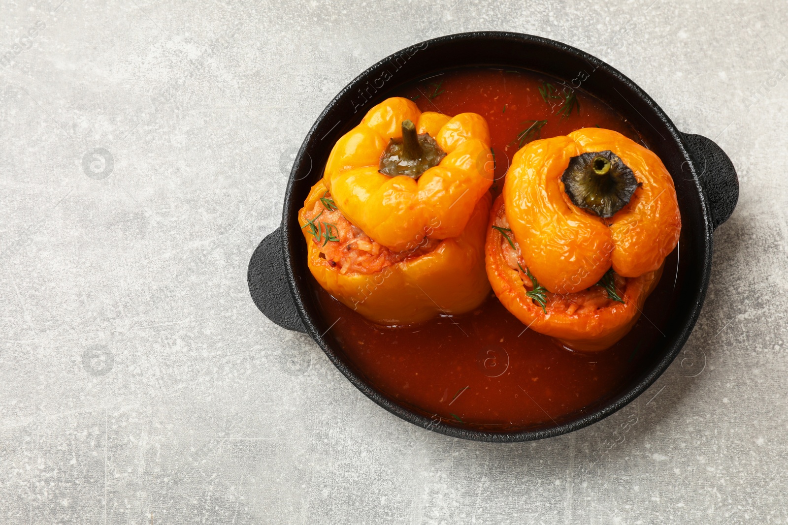 Photo of Tasty stuffed peppers on light grey table, top view. Space for text