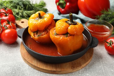 Photo of Tasty stuffed peppers on light grey table, closeup