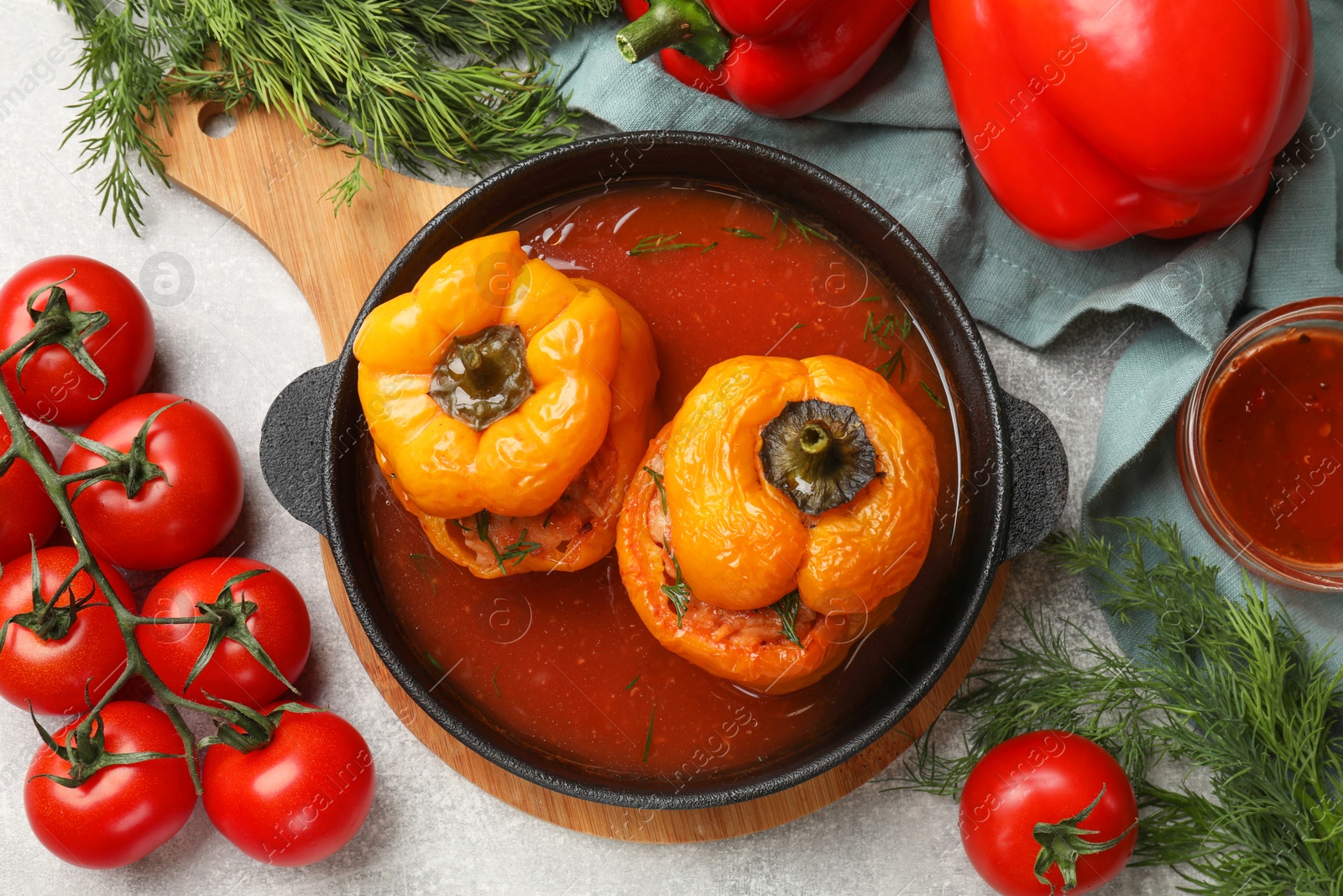 Photo of Tasty stuffed peppers, spices and products on light grey table, flat lay