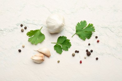 Fresh coriander leaves, garlic and peppercorns on light textured table, flat lay