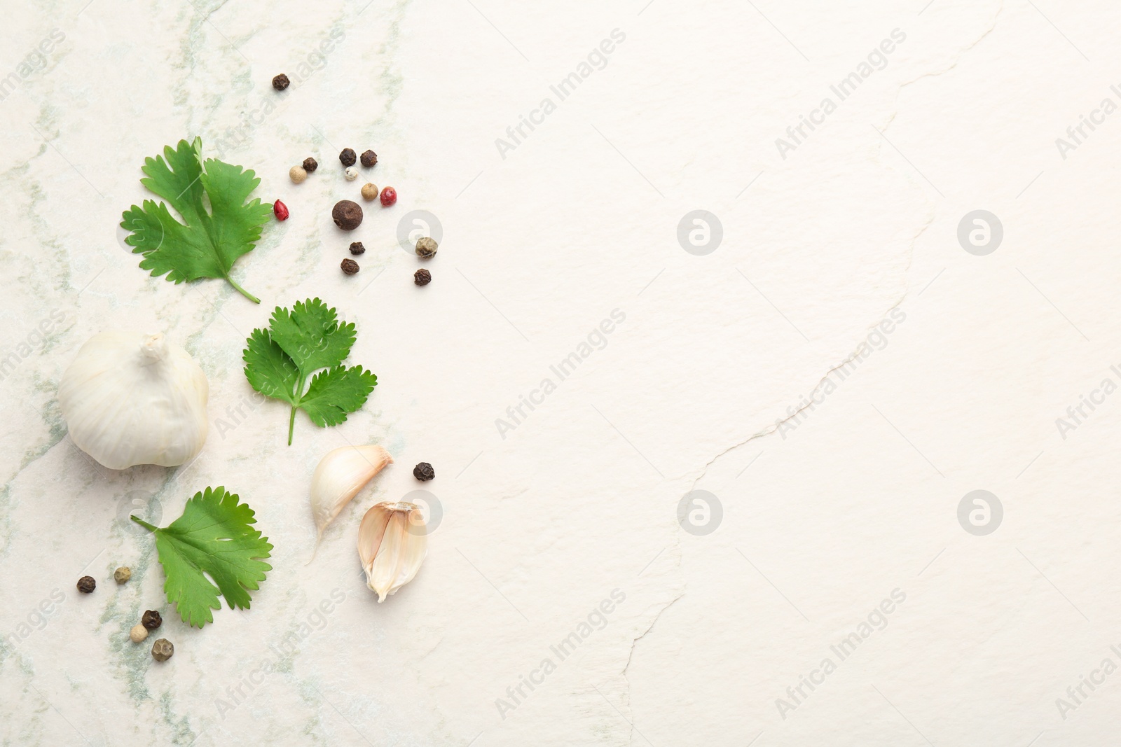 Photo of Fresh coriander leaves, garlic and peppercorns on light textured table, flat lay. Space for text