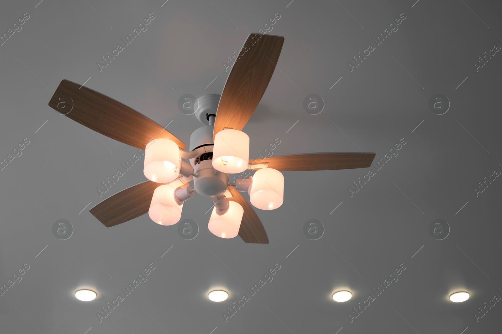 Photo of Ceiling fan with lamps indoors, low angle view