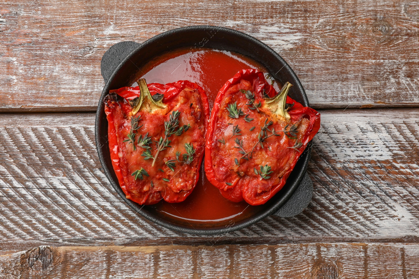 Photo of Tasty stuffed peppers in dish on table, top view