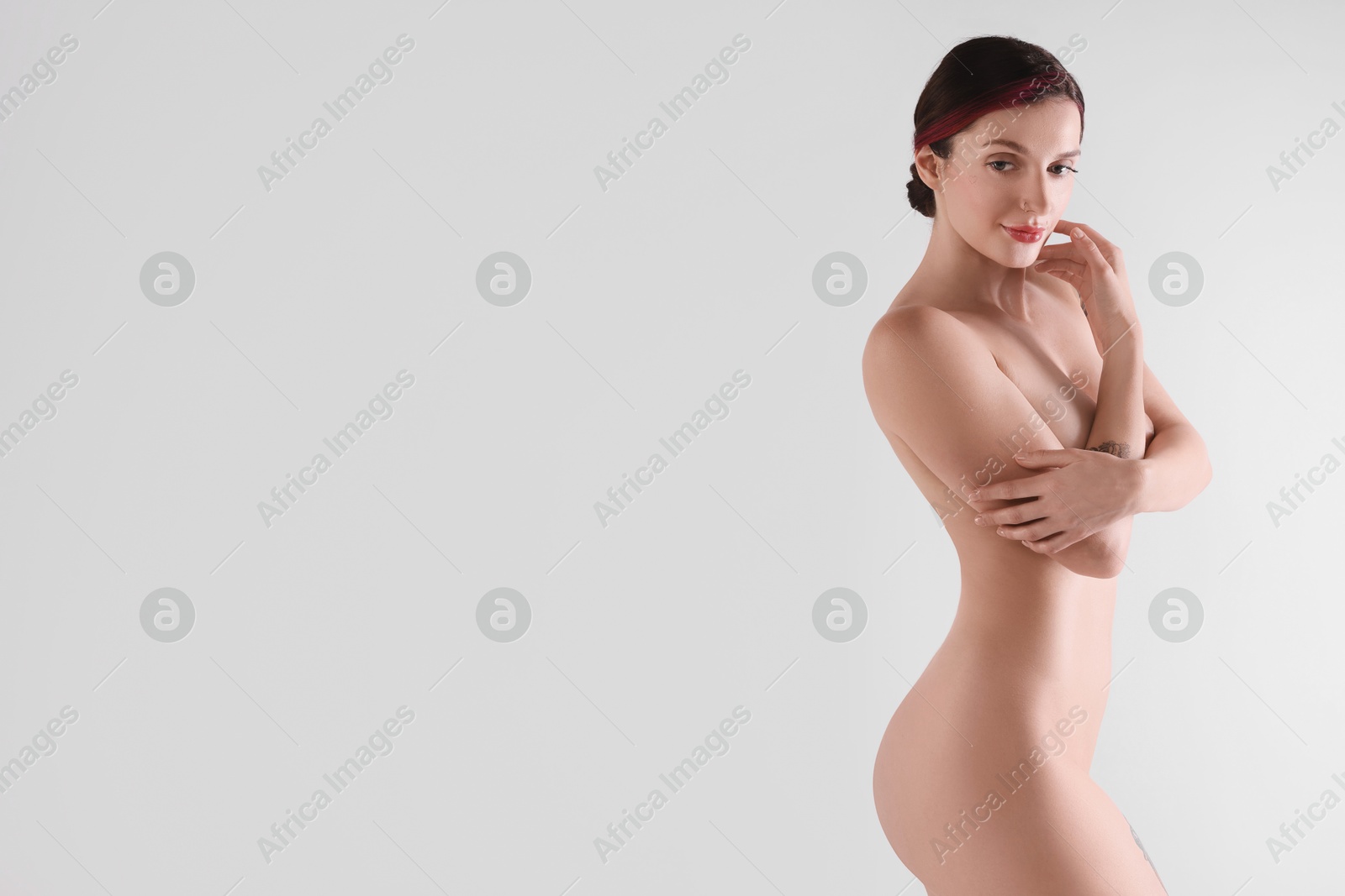 Photo of Beautiful nude woman posing on white background