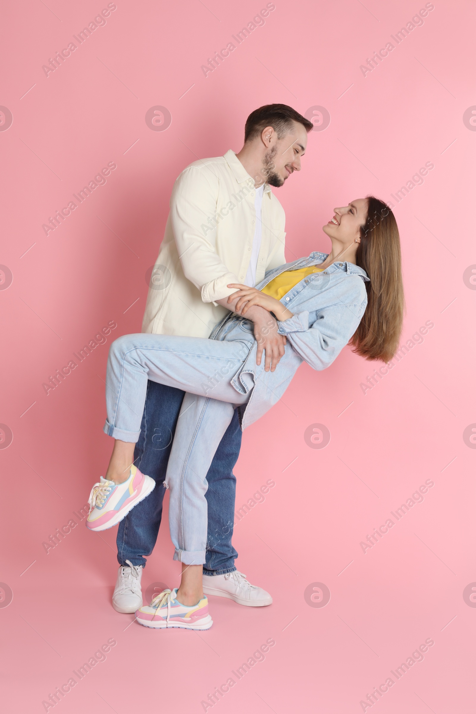 Photo of Happy couple dancing on pink background. Strong relationship