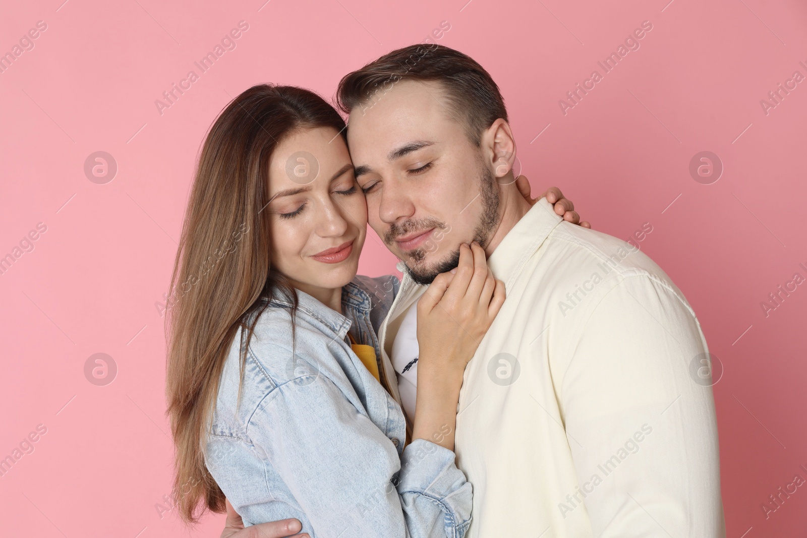 Photo of Happy couple hugging on pink background. Strong relationship