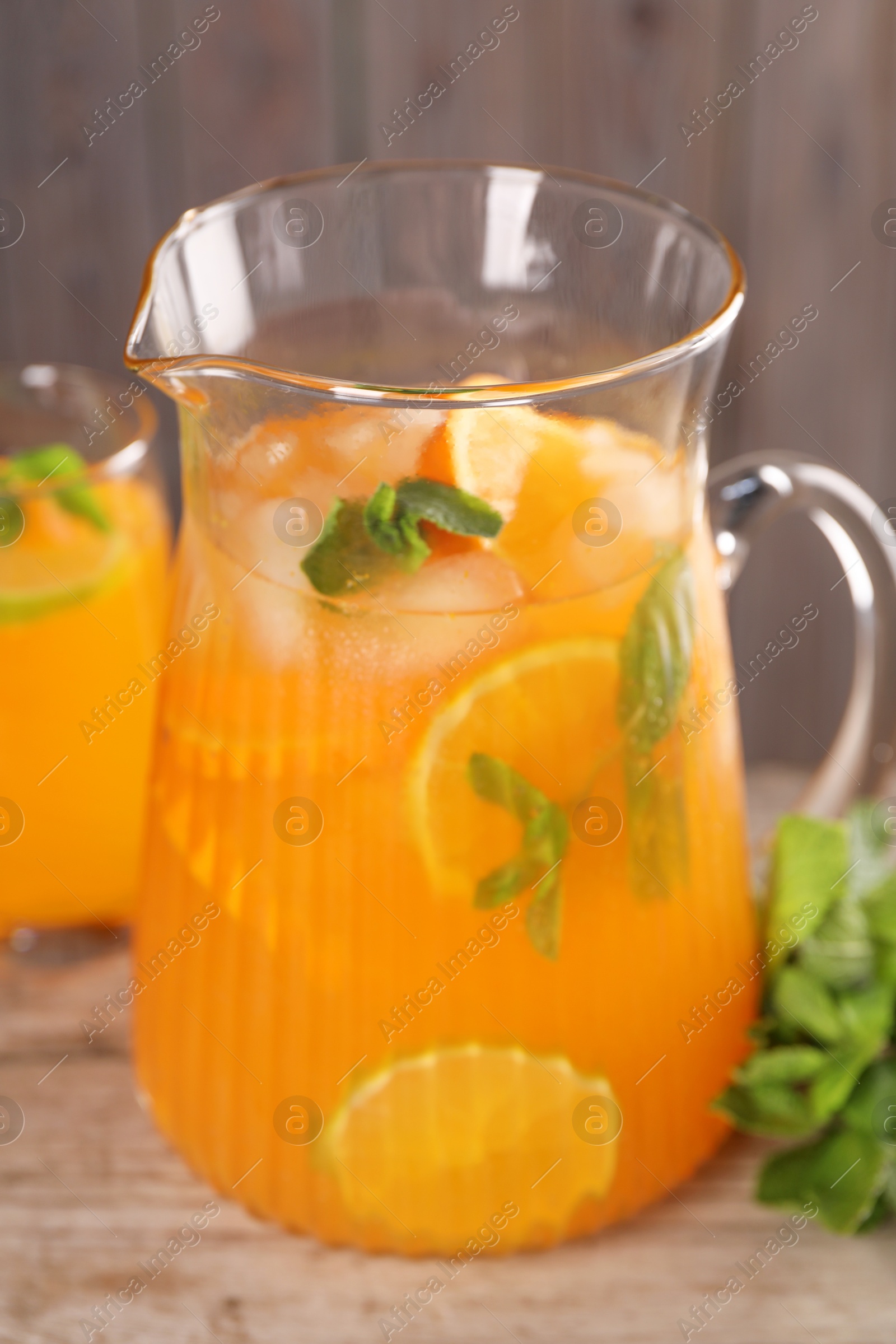 Photo of Freshly made lemonade in jug and mint on wooden table