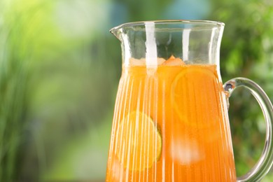 Photo of Freshly made lemonade in jug outdoors, space for text