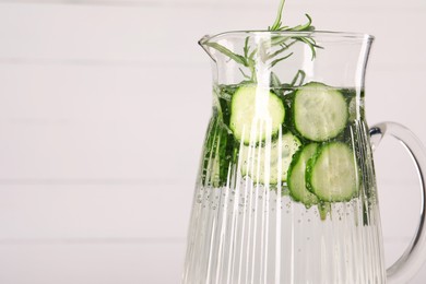 Photo of Refreshing cucumber water with rosemary in jug on white background, closeup. Space for text