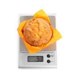 Photo of Kitchen scale with muffin isolated on white, top view