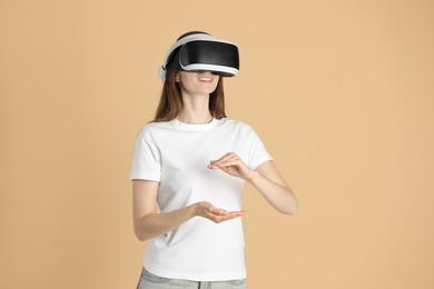 Smiling woman using virtual reality headset on beige background