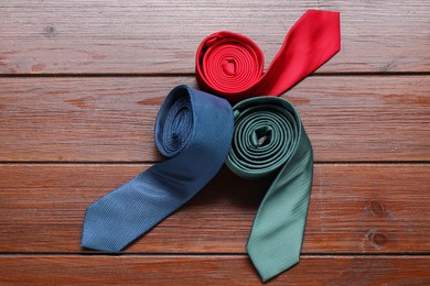 Different neckties on wooden table, flat lay